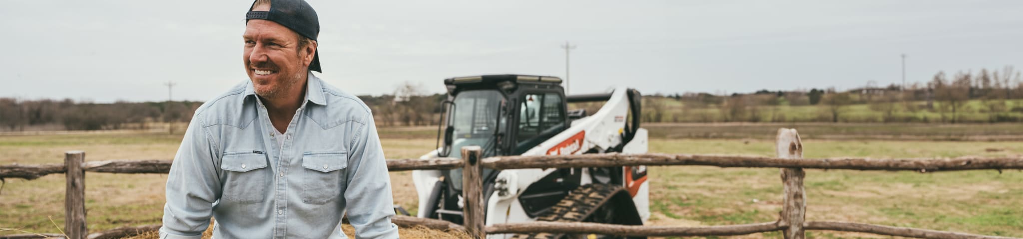 Chip Gaines Is Shown on His Property; a Bobcat T86 Compact Track Loader Is in the Background