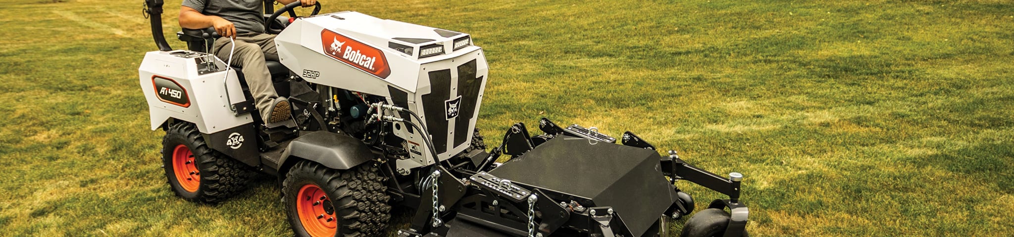 A Man Mows a Residential Lawn Using the Bobcat AT450 Tractor and an AirFX Mower Deck