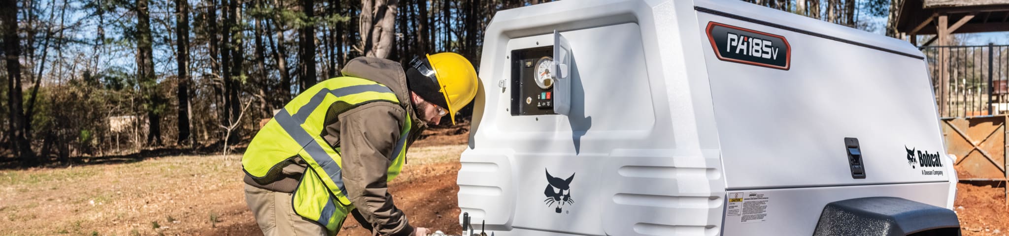 An Operator Connects a Hose to a PA185 Portable Air Compressor 