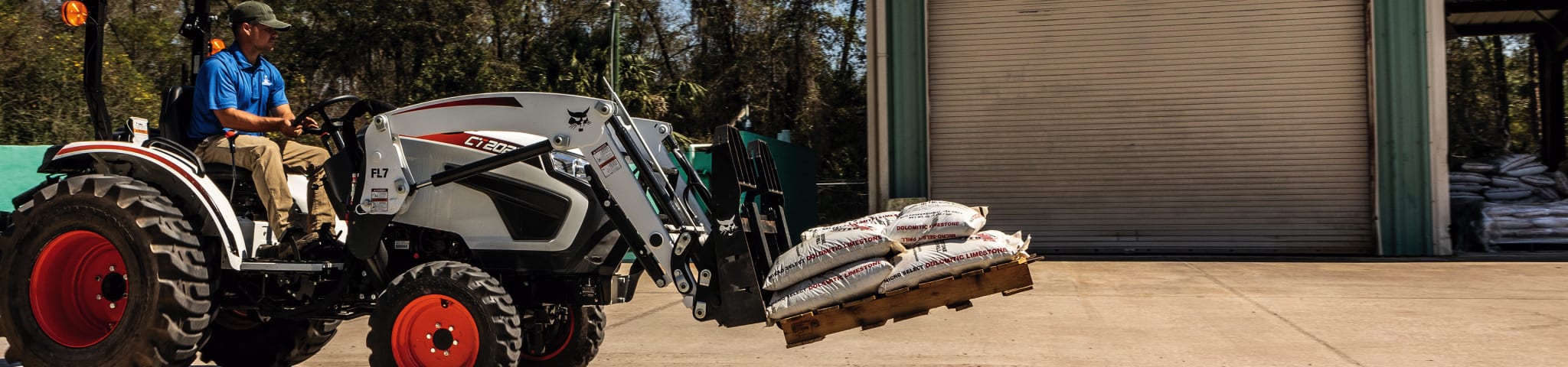 An Operator Carries Bags of Mulch Using a Bobcat CT2025 Compact Tractor With a Pallet Fork Attachment 