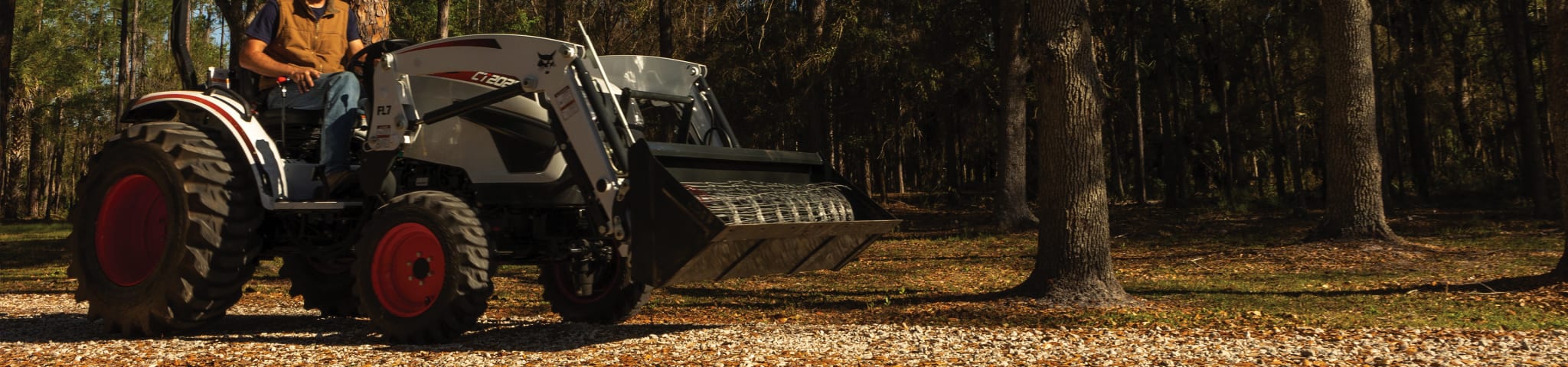 A Bobcat CT2025 Compact Tractor Operator Moves Wire Fencing Using the Front-End Loader