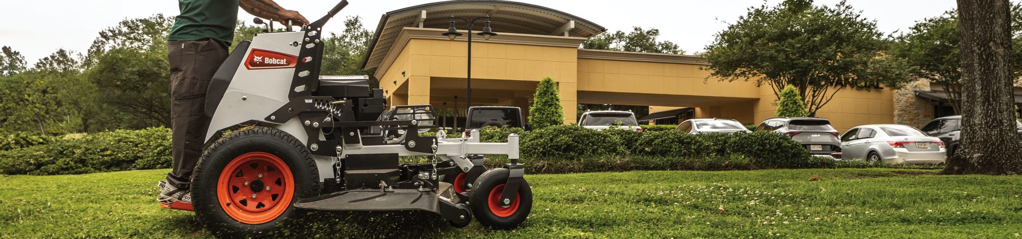 Operator Uses a Bobcat ZS4000 Stand-On Zero-Turn Mower to Cut Grass on a Commercial Property 