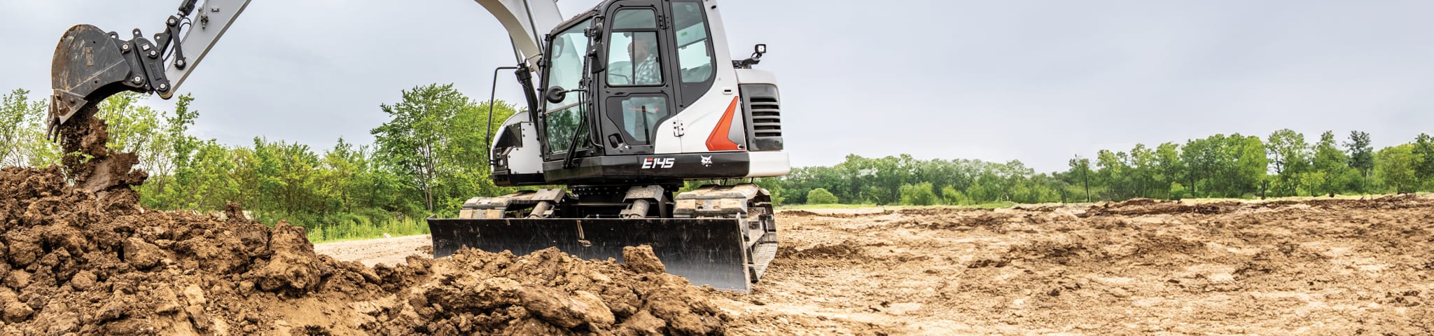 Bobcat E145 Releasing Dirt Onto Pile After Heavy Digging