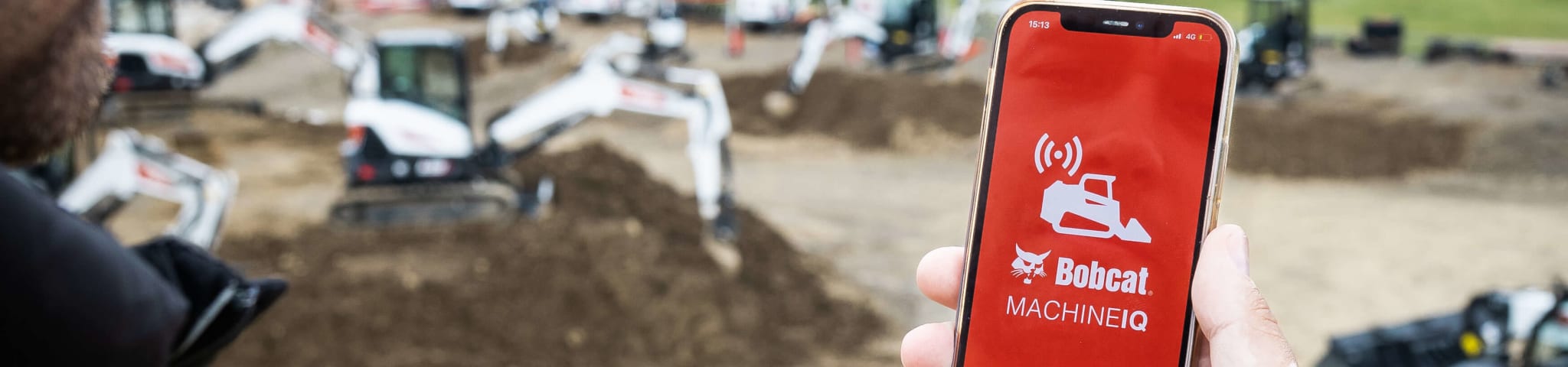 Een man die de Bobcat Machine IQ-app gebruikt om zijn E50z-minigraafmachine te controleren.