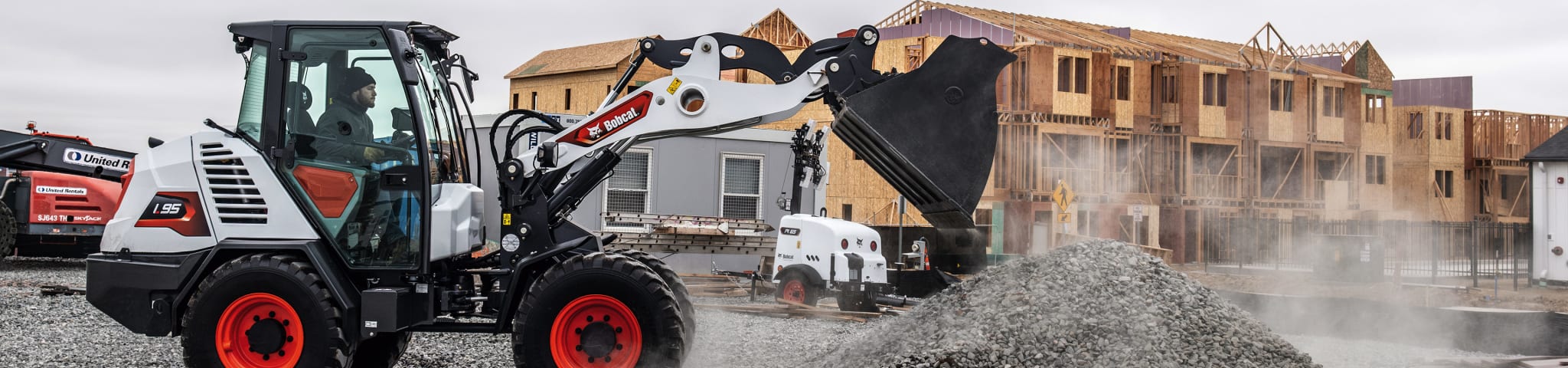 Operator Dumps Gravel From the Bucket of a Bobcat L95 Compact Wheel Loader on a Construction Site