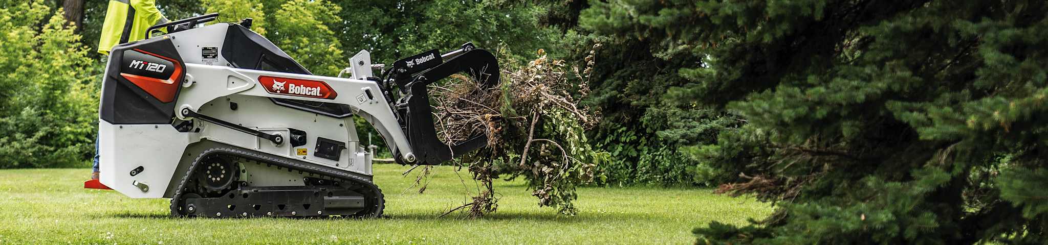 An Operator Grabs a Bundle of Fallen Brush With a Root Grapple Attachment on an MT120 Mini Track Loader