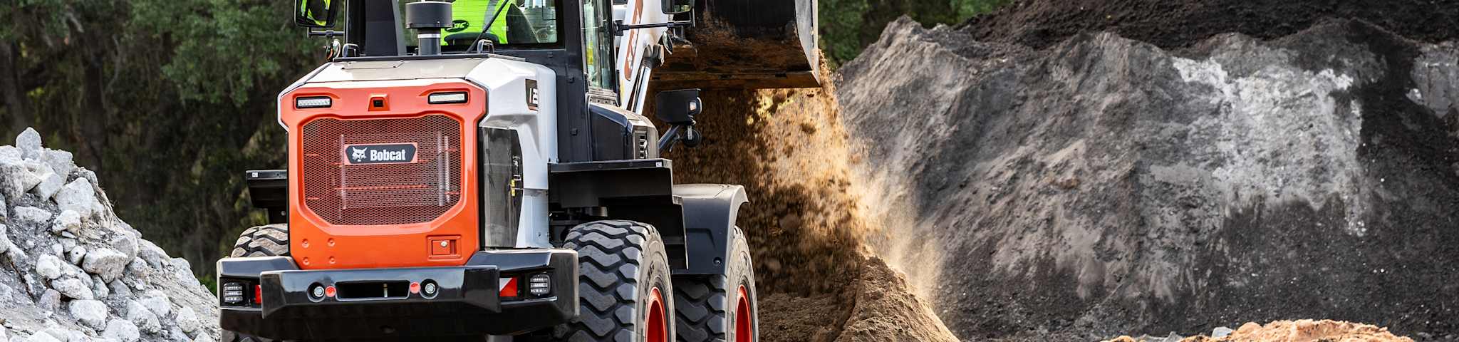An Operator Dumps Gravel Onto a Pile Using a Bobcat L235 Large Wheel Loader