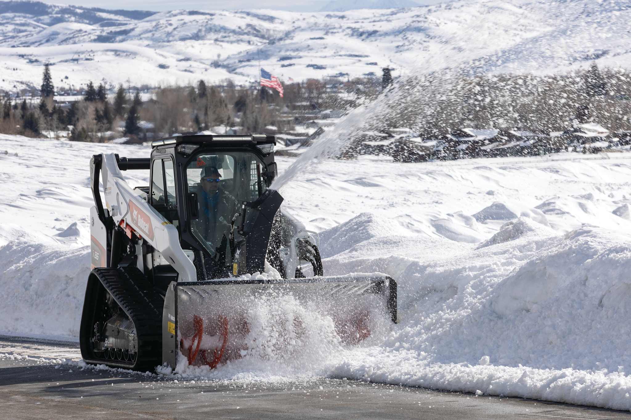 Bobcat T86 compact track loader operating a snowblower attachment on a winter day