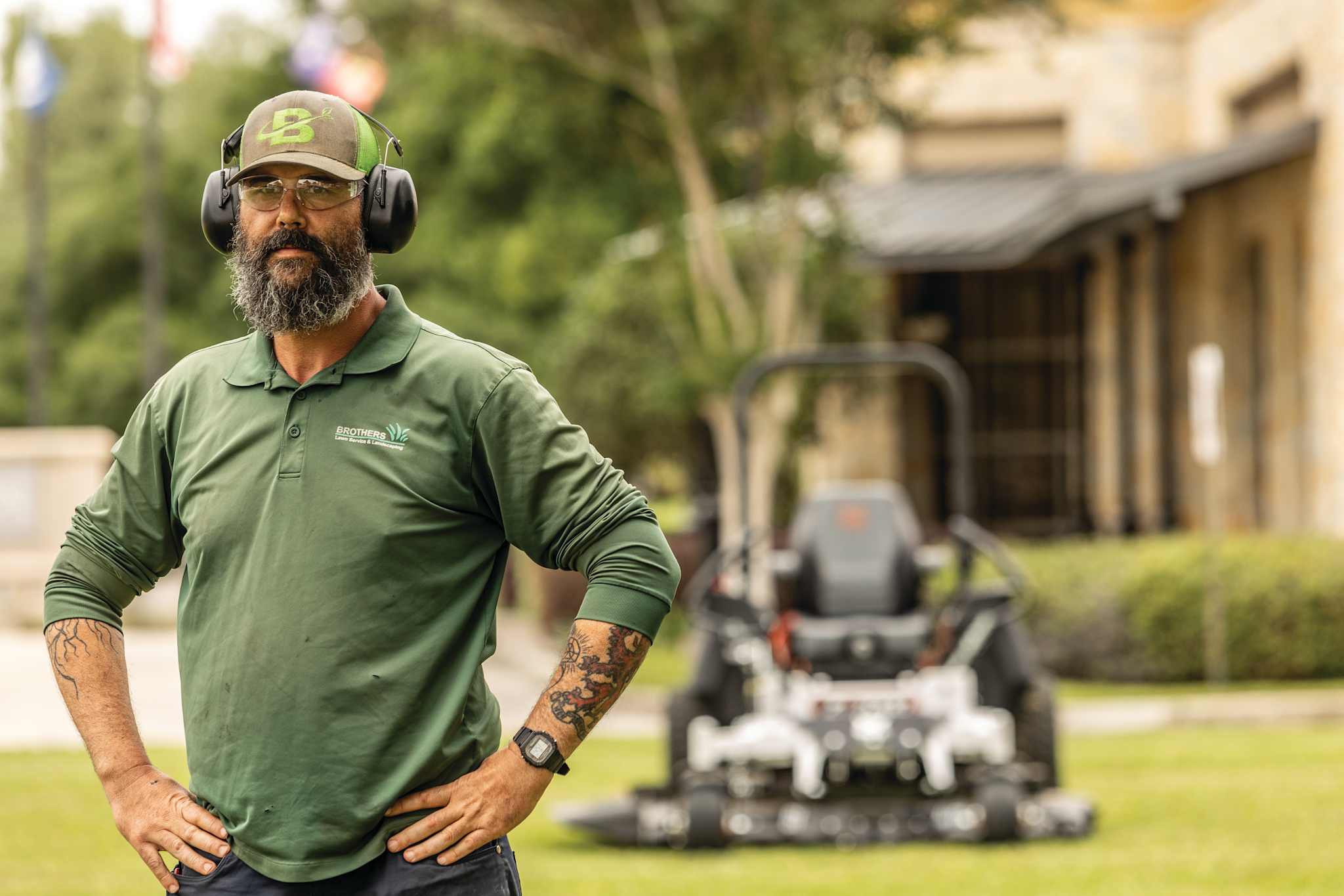 Professional operator stoically standing with hands on hips with Bobcat ZT7000 zero-turn riding mower in background
