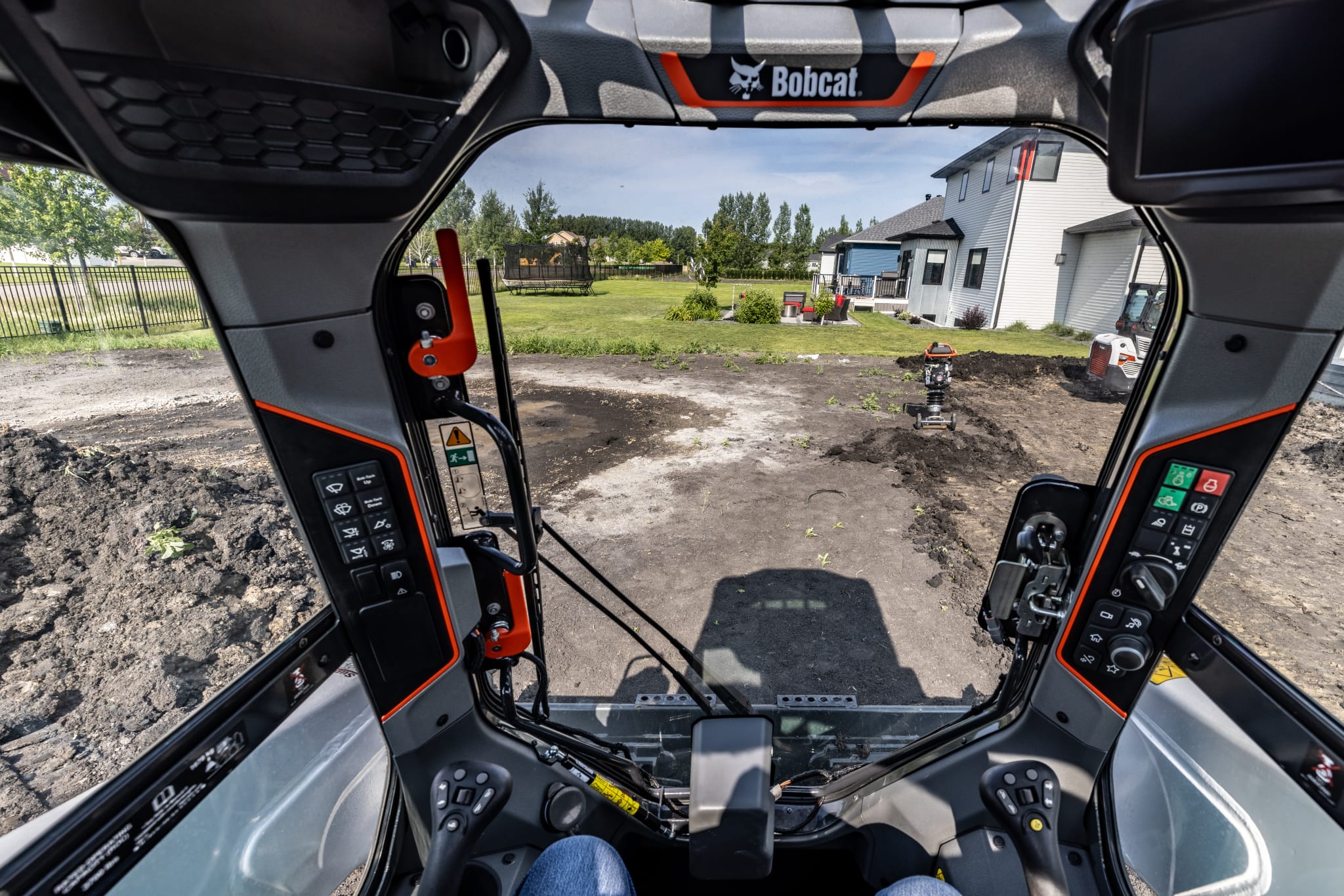 Operator inside Bobcat loader with sealed cab for clear visibility and dust protection