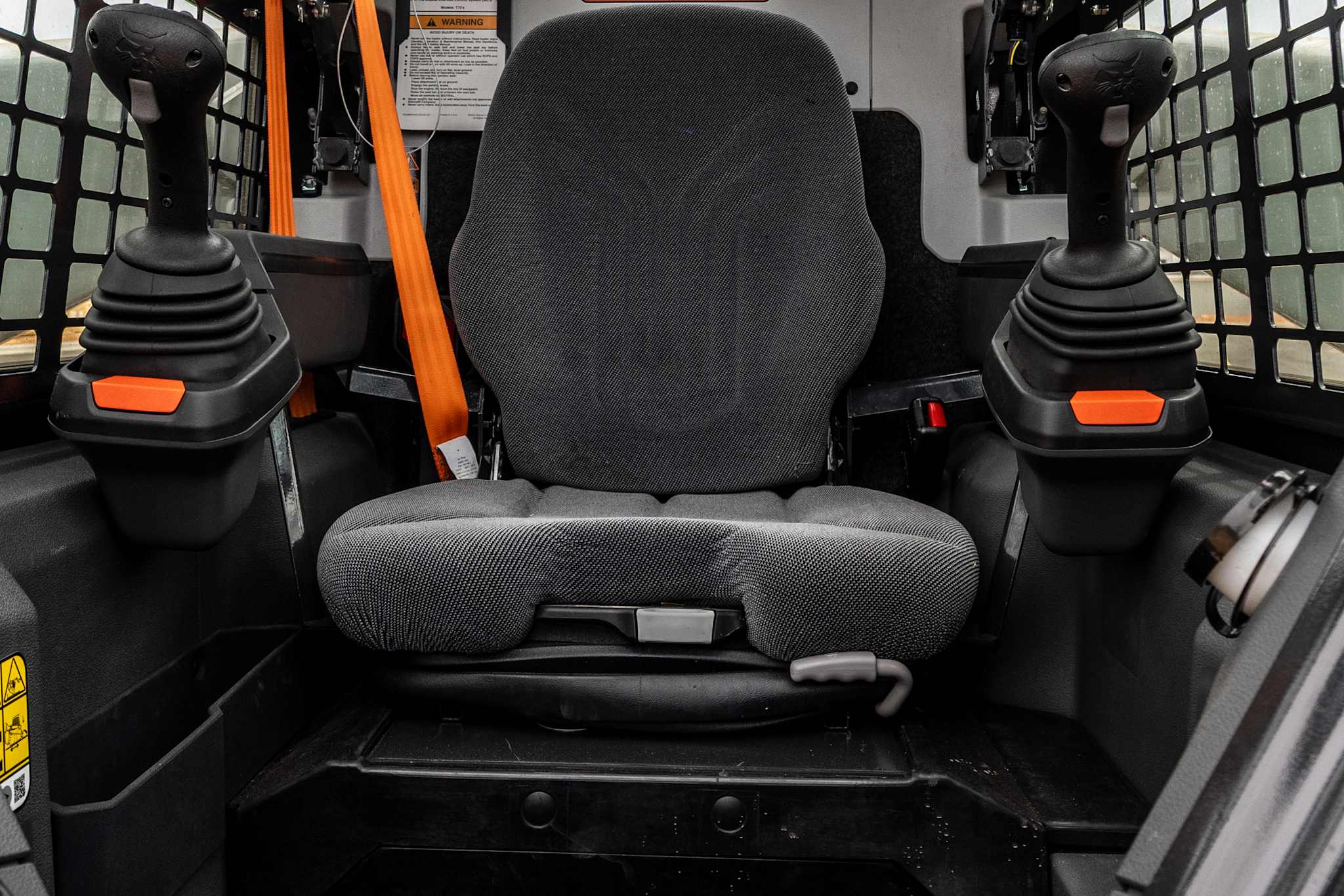 Interior View of the Operator Station in a Bobcat Pro T76-2 Showing the Adjustable Seat and Joystick Controls