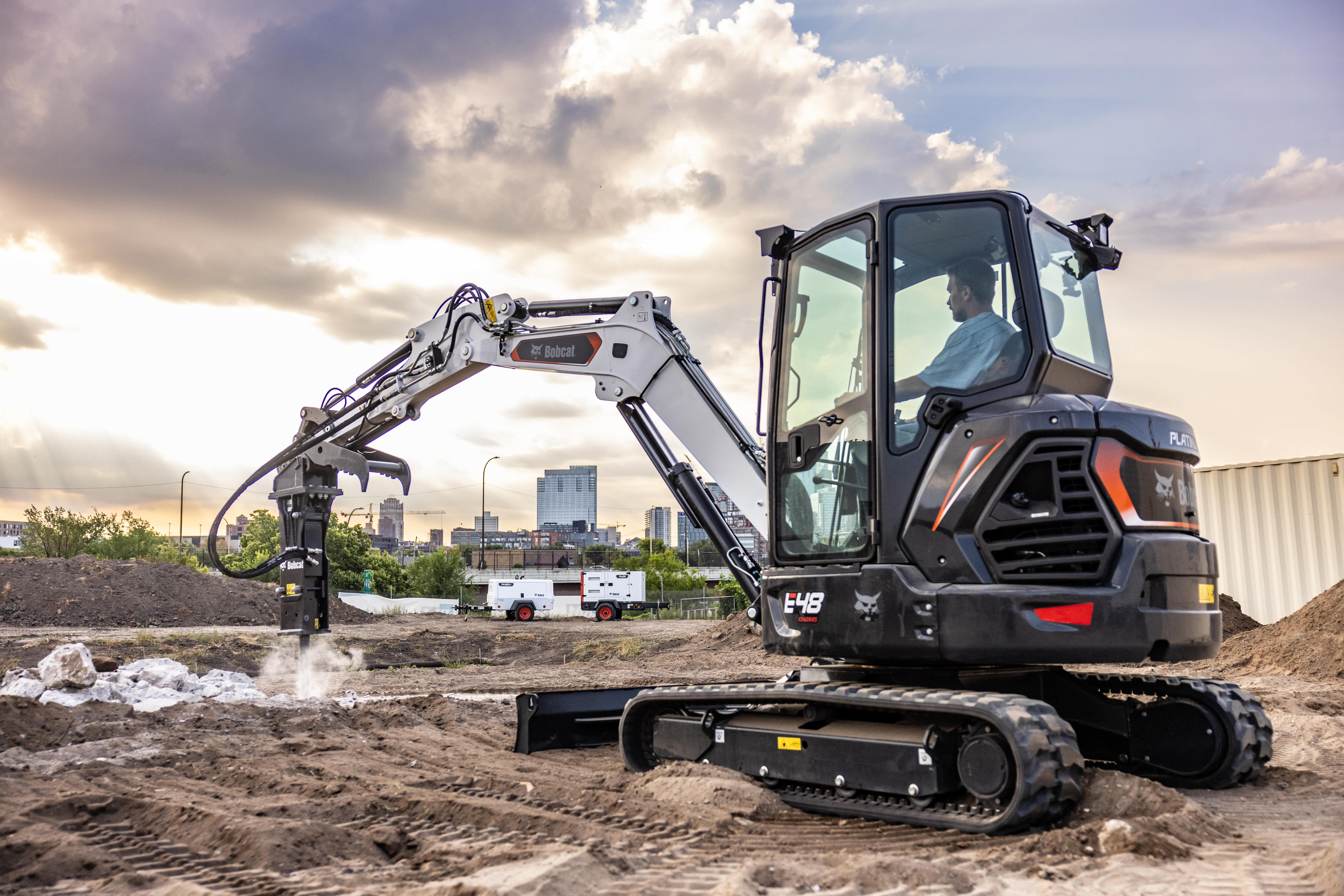 An Operator Breaks Up Concrete Using a Bobcat E48 Compact Excavator and a Nitrogen Breaker