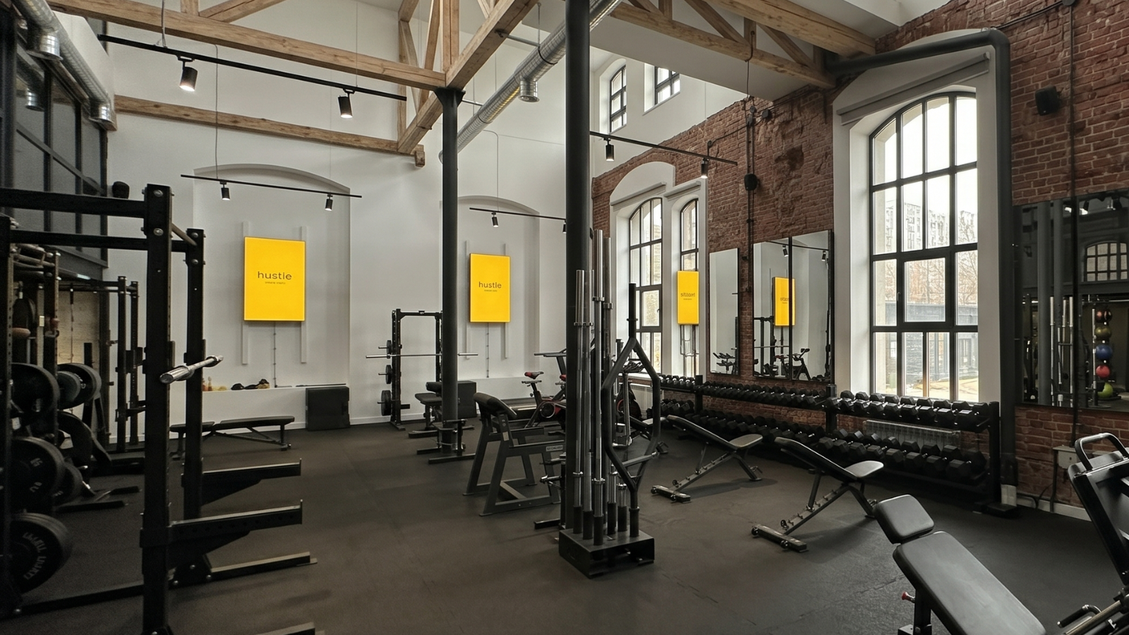 Sala główna Hustle Fitness z drewnianymi belkami pod sufitem