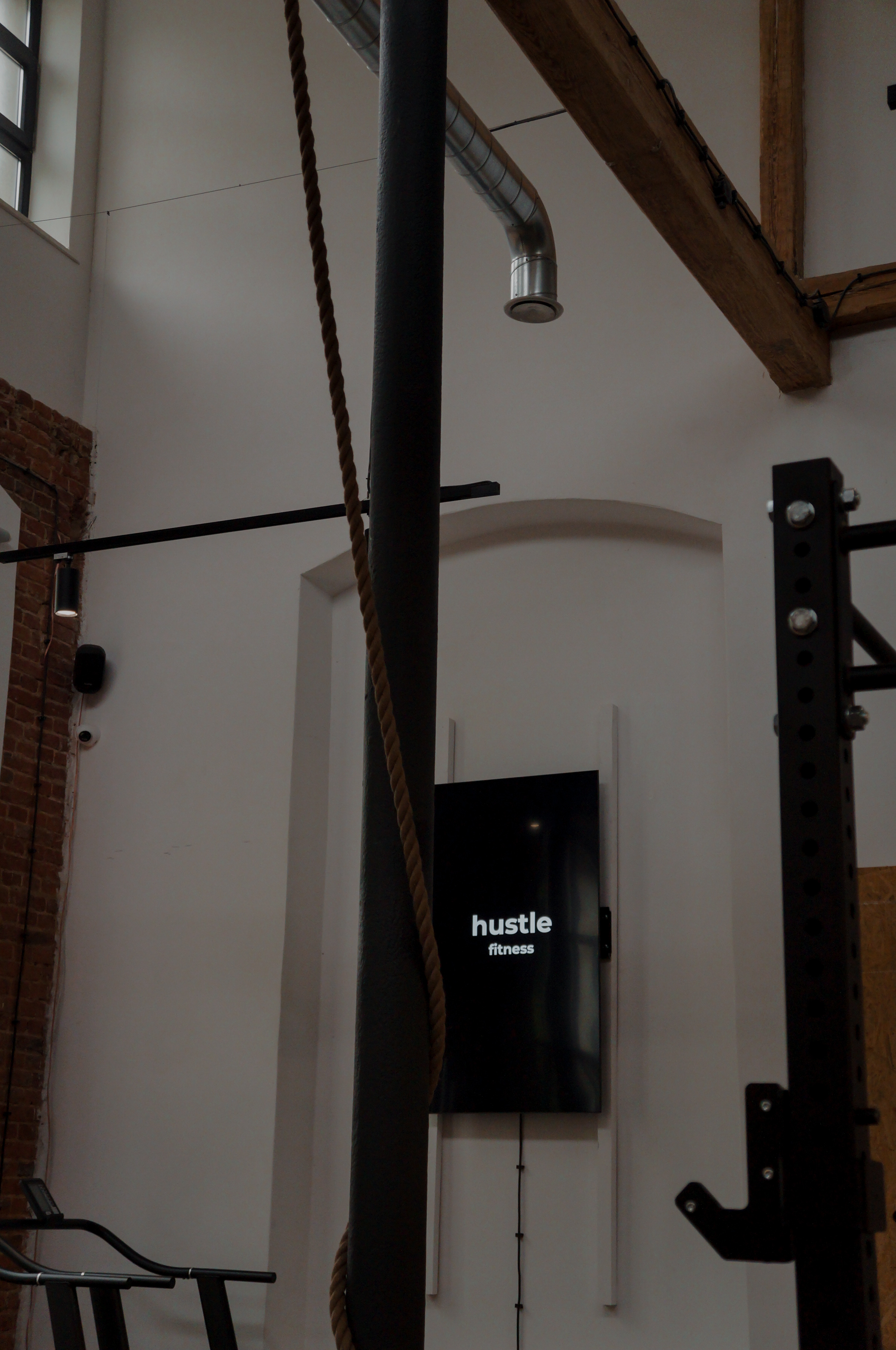 Loft z drewnianymi belkami i ekranem z logo Hustle