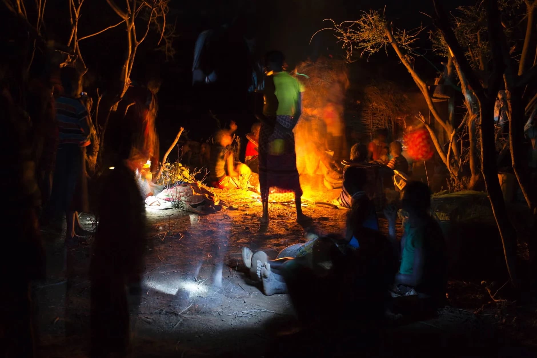 Members of the Pokot tribe gather round a fire the evening before the ceremony