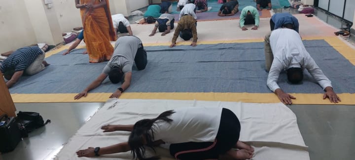 Students practising floor stretches on yoga mats