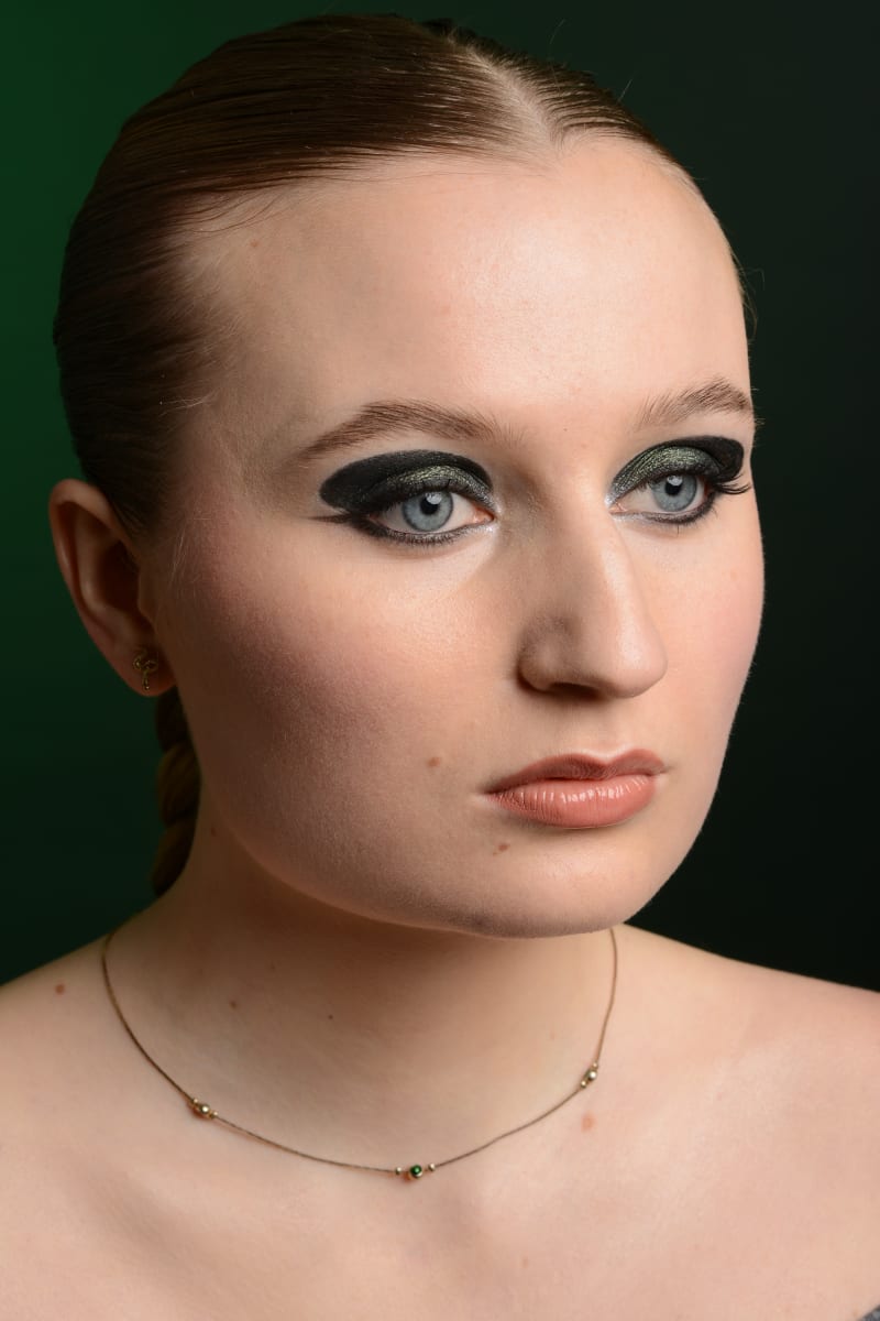 Maquillage smoky graphique fond vert foncé par Léna makeup artist Paris