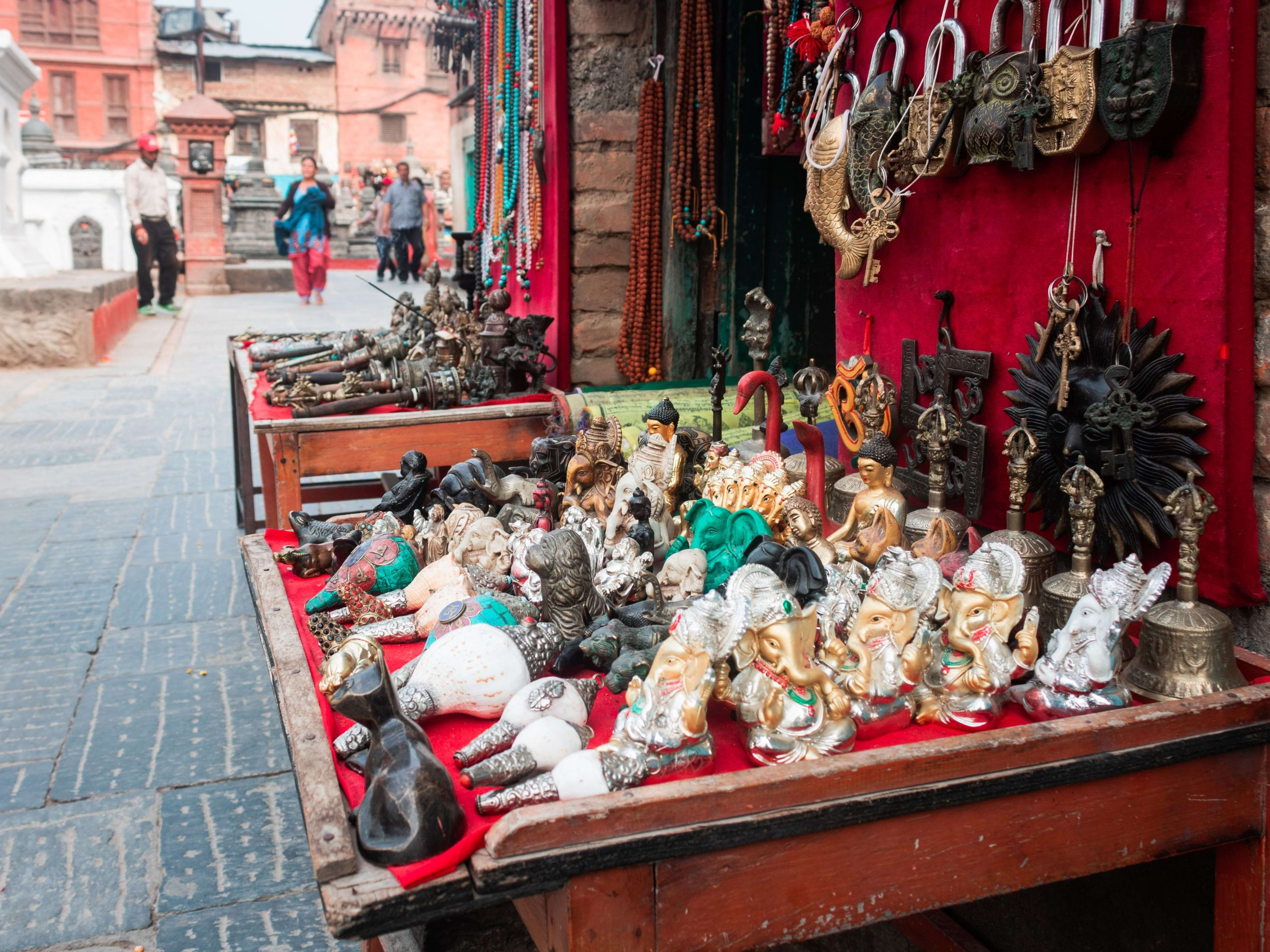 A stall selling deity figures beside a temple square