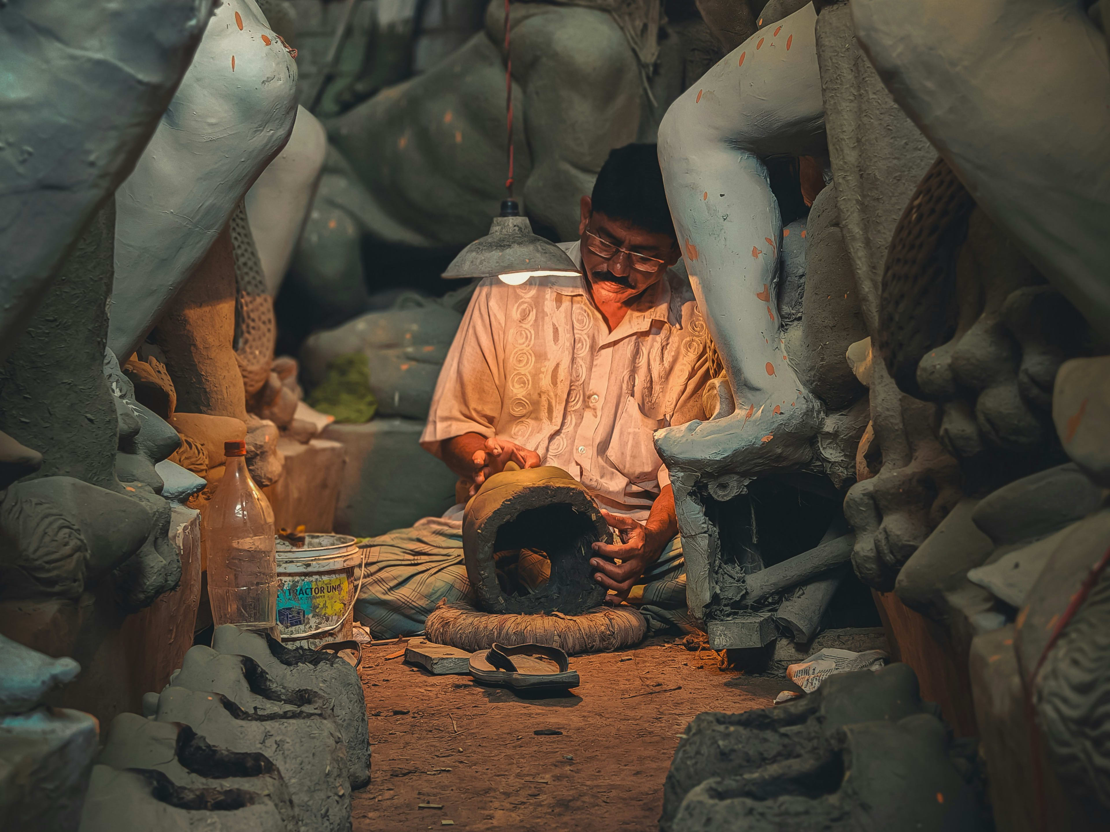 Traditional artisan working among devotional sculptures