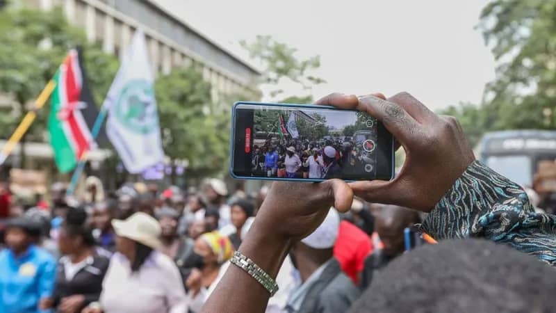 Photo of a Kenyan recording a protest on his phone. /TECHWEEZ