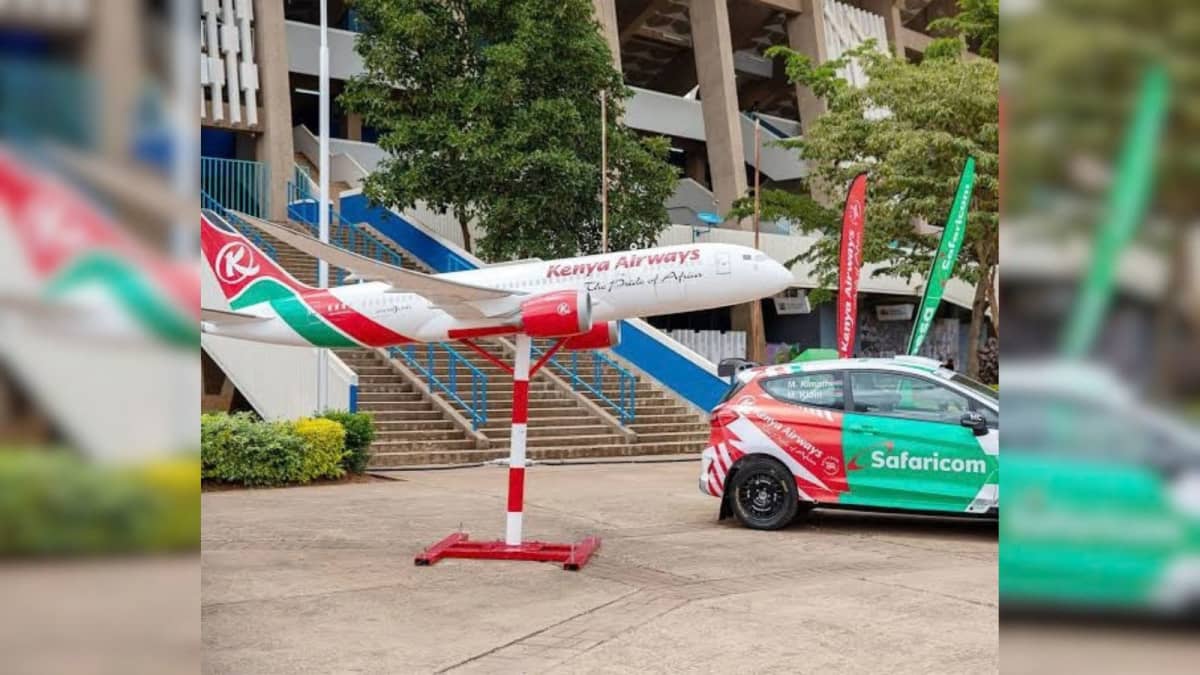 A photo of a model Kenya Airways passenger aircraft and a rally car with KQ and Safaricom livery at Kasarani Stadium. /KENYA AIRWAYS