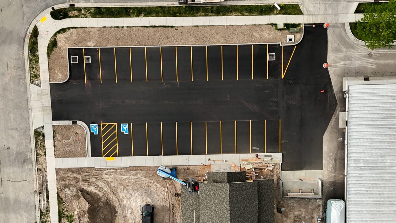 After: commercial parking lot subbase before and paved striped lot after