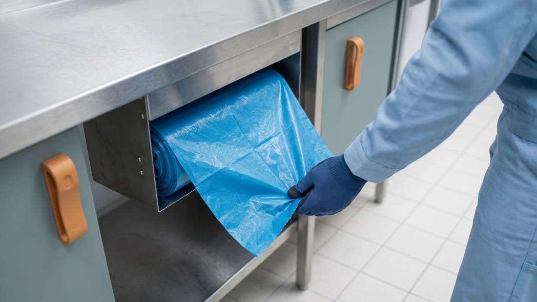 Frischer LDPE-Müllbeutel wird aus Rollen-Spender gezogen