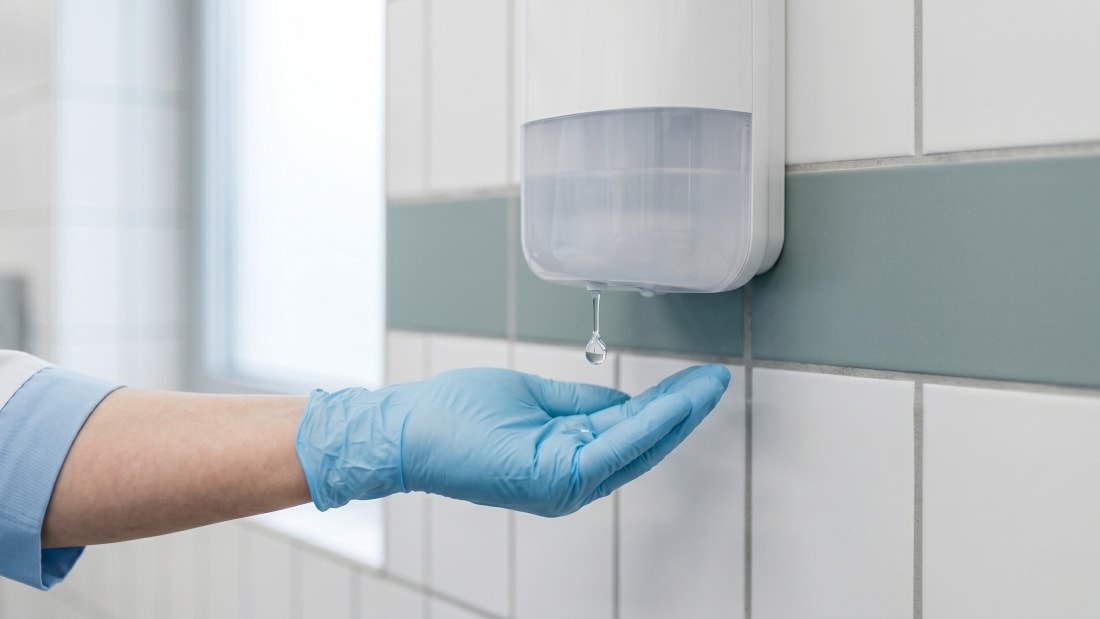 Hygienische Händedesinfektion an einem Touch-free Sensor-Spender