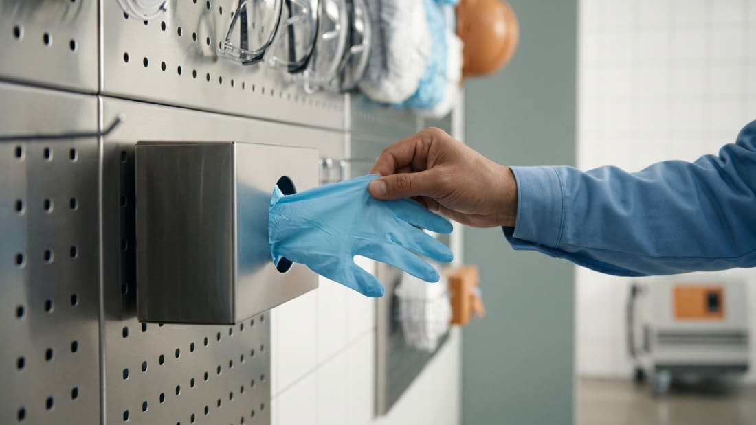 Nitril-Einweghandschuhe werden aus dem Wandspender entnommen