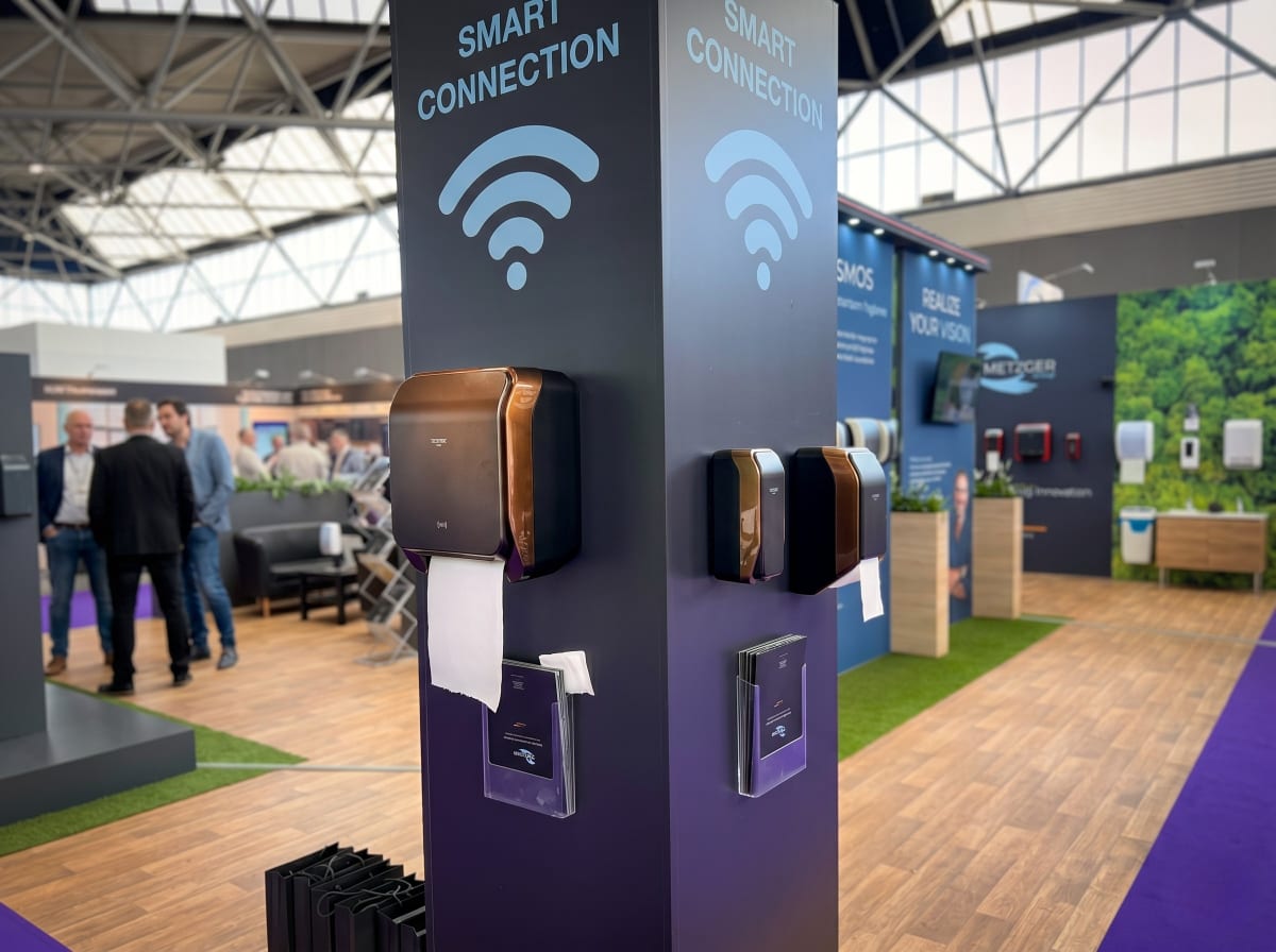 Metzger Cosmos 2 Smart Connection Spender — wandmontiert in dunklem Premium-Design auf Messestand