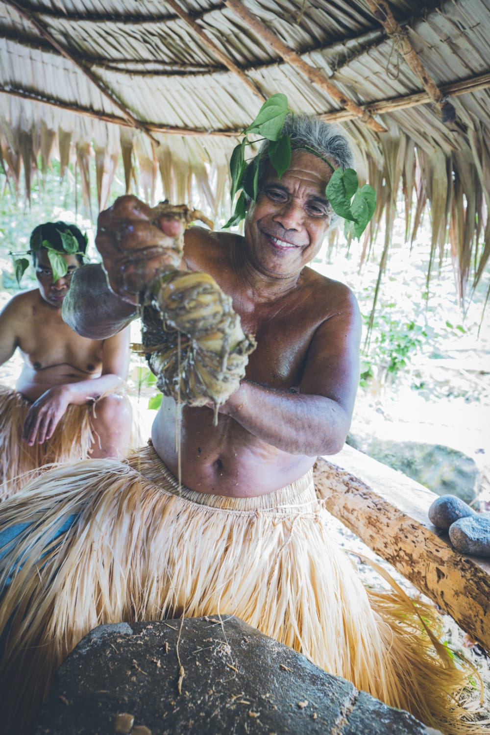 A Pohnpeian cultural demonstration beneath a thatched shelter
