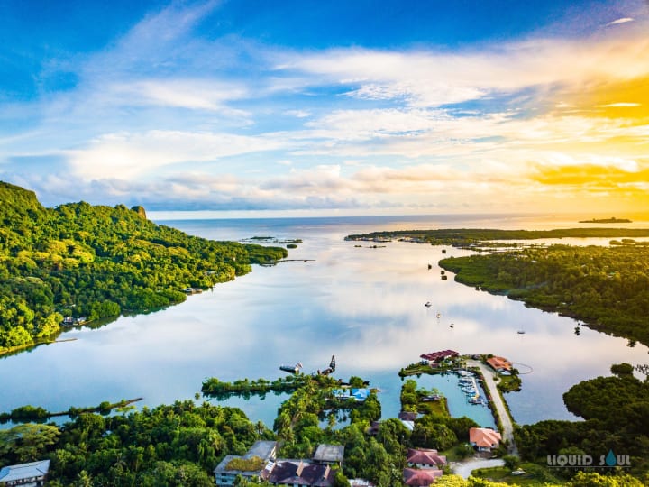 Green islands and still water in Pohnpei’s lagoon at sunset