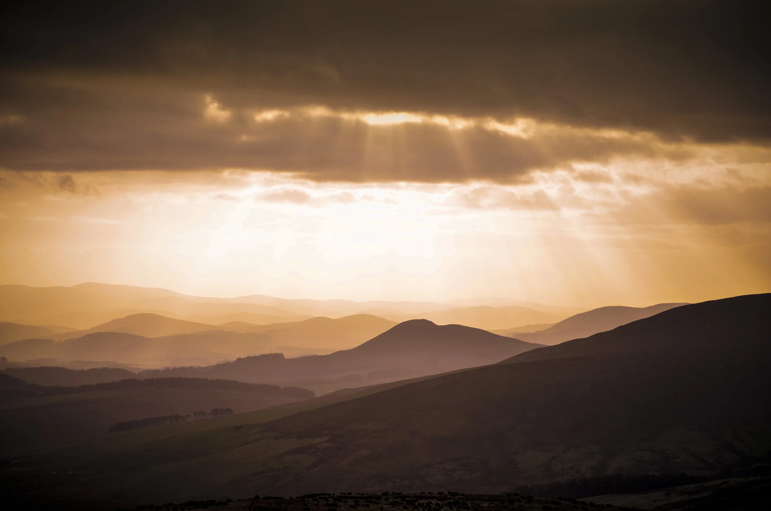 A hazy view of mountains at sunrise.