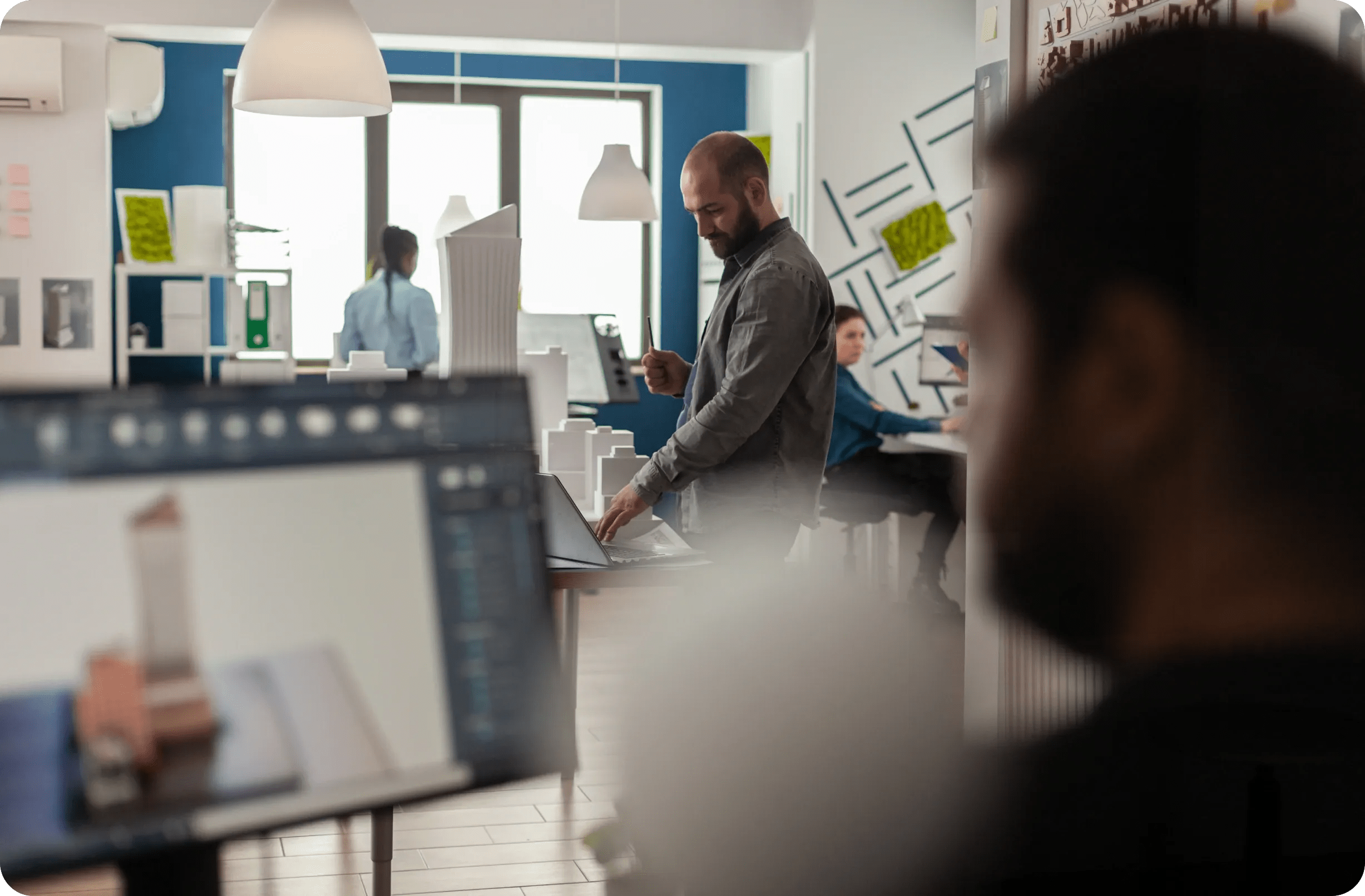 Équipe au travail dans un bureau, écran de modélisation 3D au premier plan