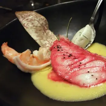 Poached White Cod Loin in Beetroot Broth Prawns-Mascarpone, Avocado Oil, Sweet Corn Coulis and Black Ink Salt