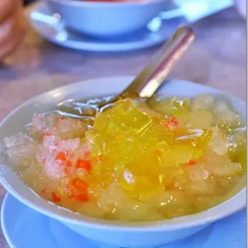 “Wan Tau Long” (Yellow Jelly) With A Squeeze Of Lime, Over A Bed Of Finely-Shaved Ice And Optional Toppings Of Chewy Red Rubies Aka ‘Sek Lau Zhi’