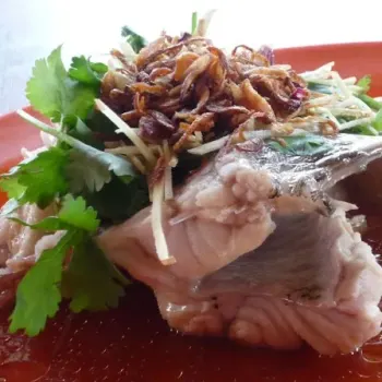 Steamed Garoupa Fish'S Tail Garnished With Deep Fried Fragrant Shallots, Coriander Leaves And Julienne Young Ginger-Seated On Good Grade Light Soy Sauce