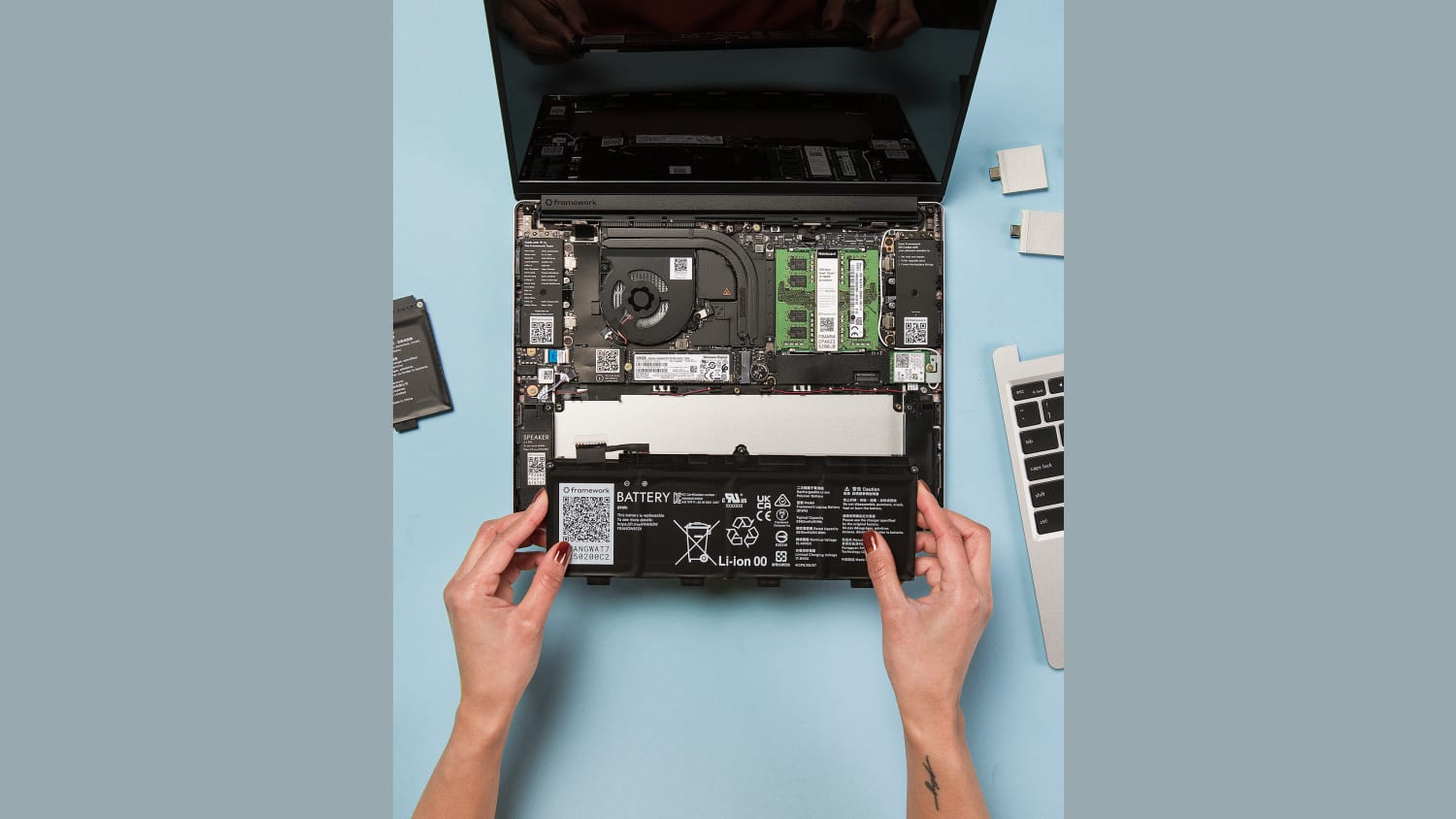 A person changes the battery on a Framework modular laptop