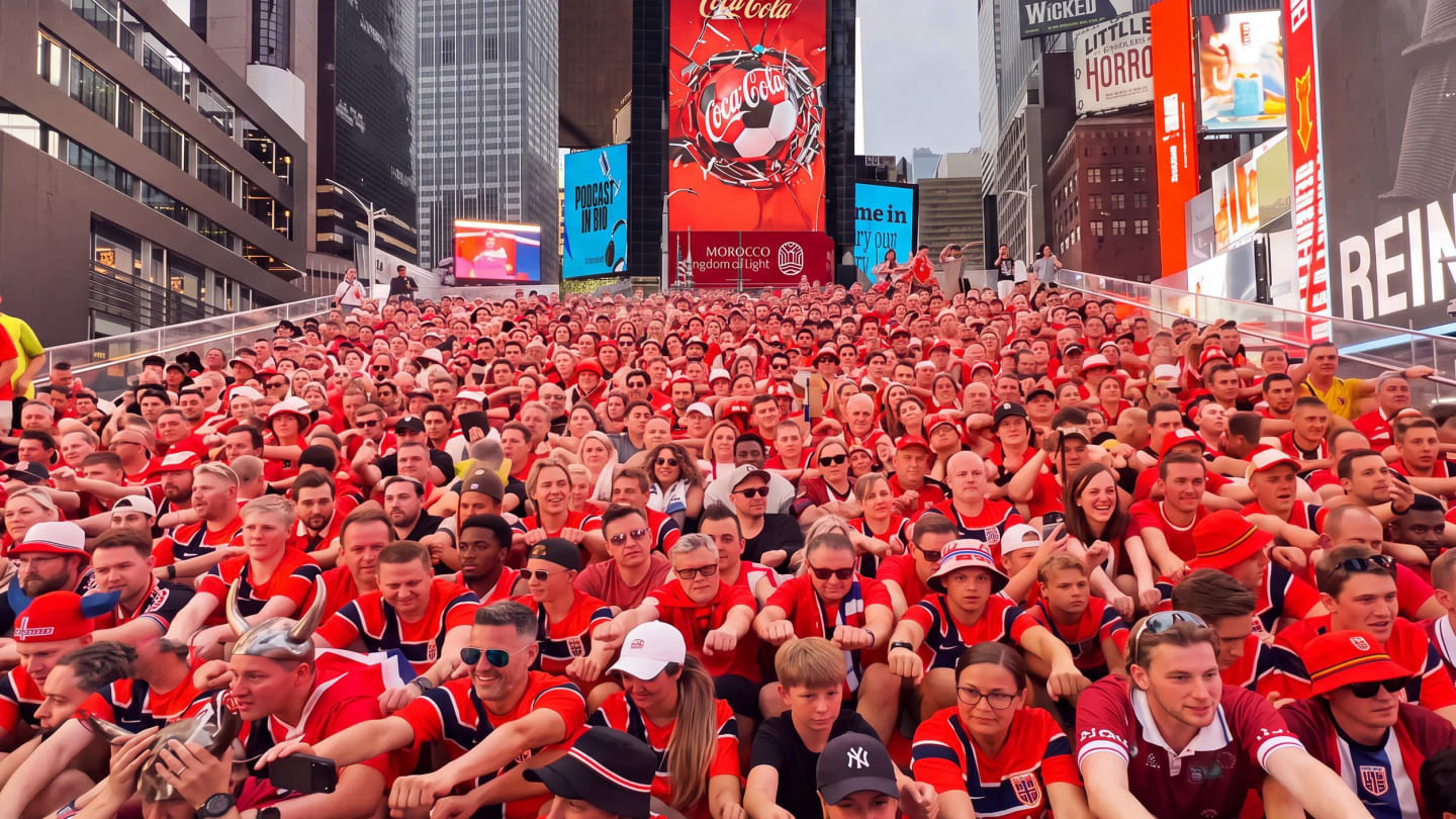 Norway fans filling Times Square with a coca-cola ad in the background