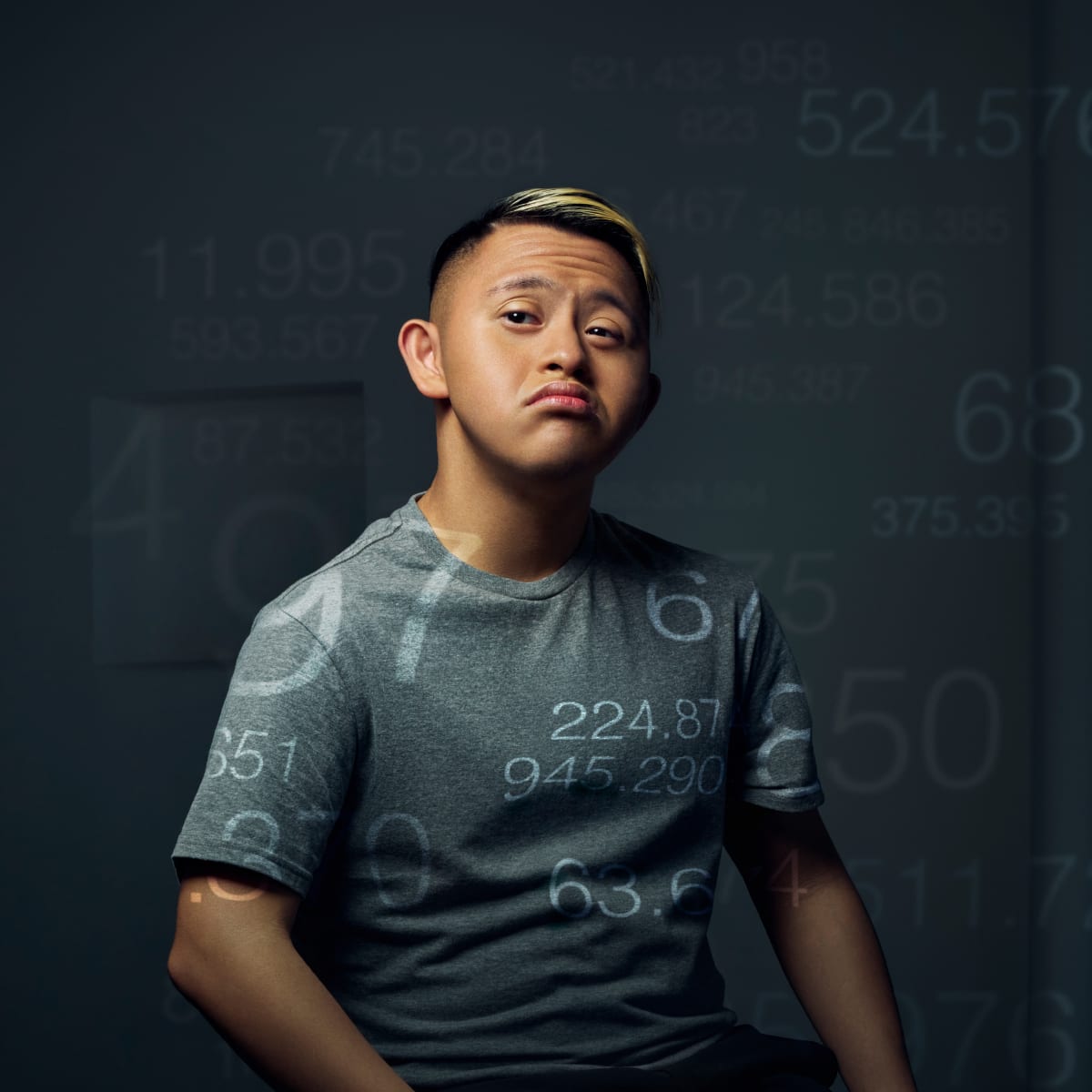 Boy with Down Syndrome wearing grey T-Shirt overlayed with numbers