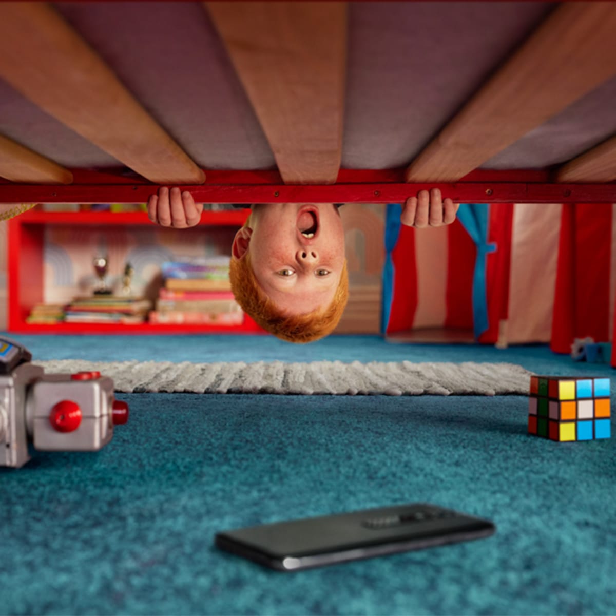 Vodafone - Home of Trade In. A young boy looks underneath his bed to find an old smart phone surrounded by old toys and books