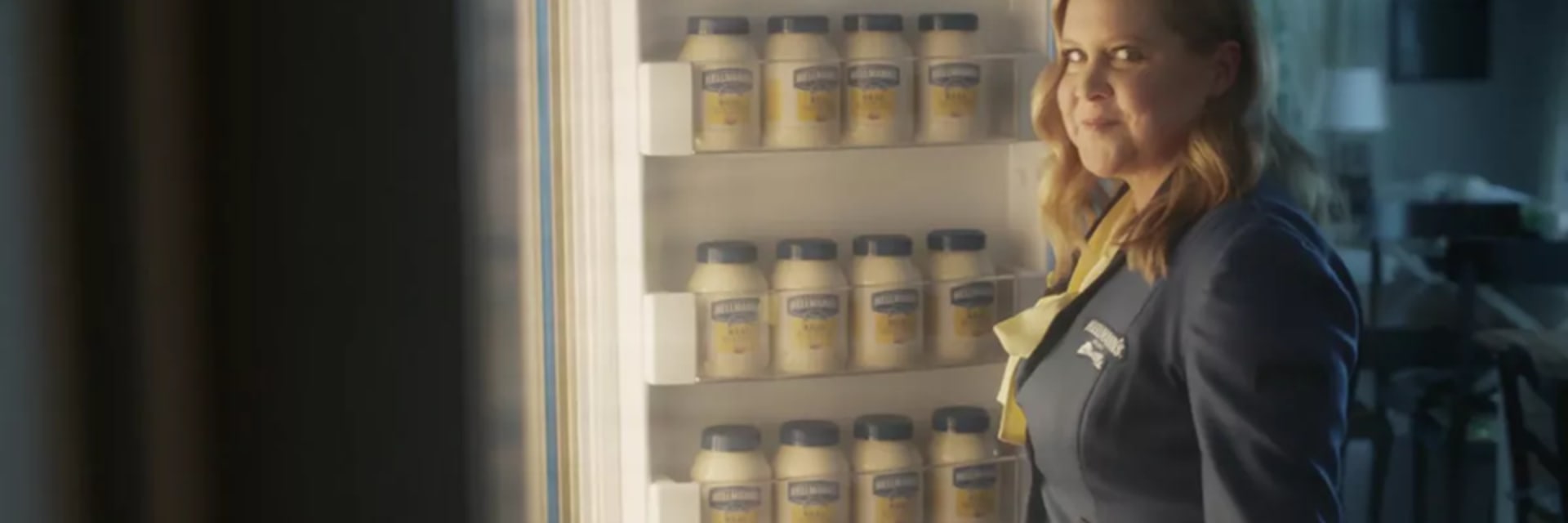 woman in front of open refrigerator filled with Hellmanns mayonaise