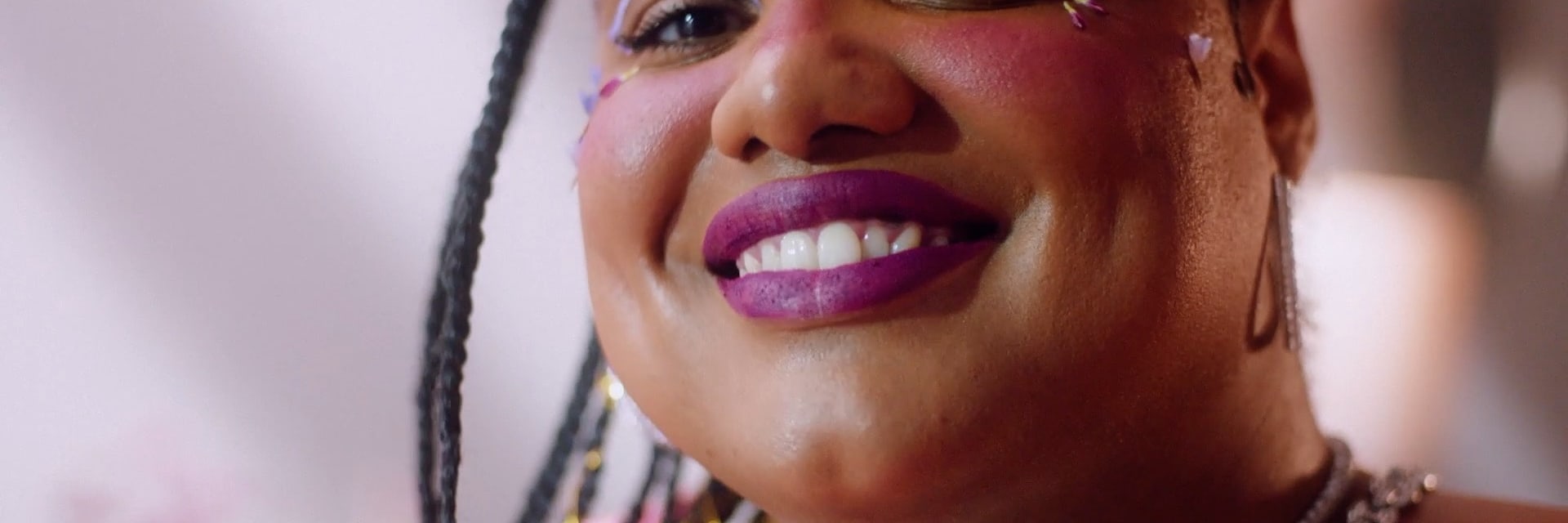 Person smiling with purple lipstick