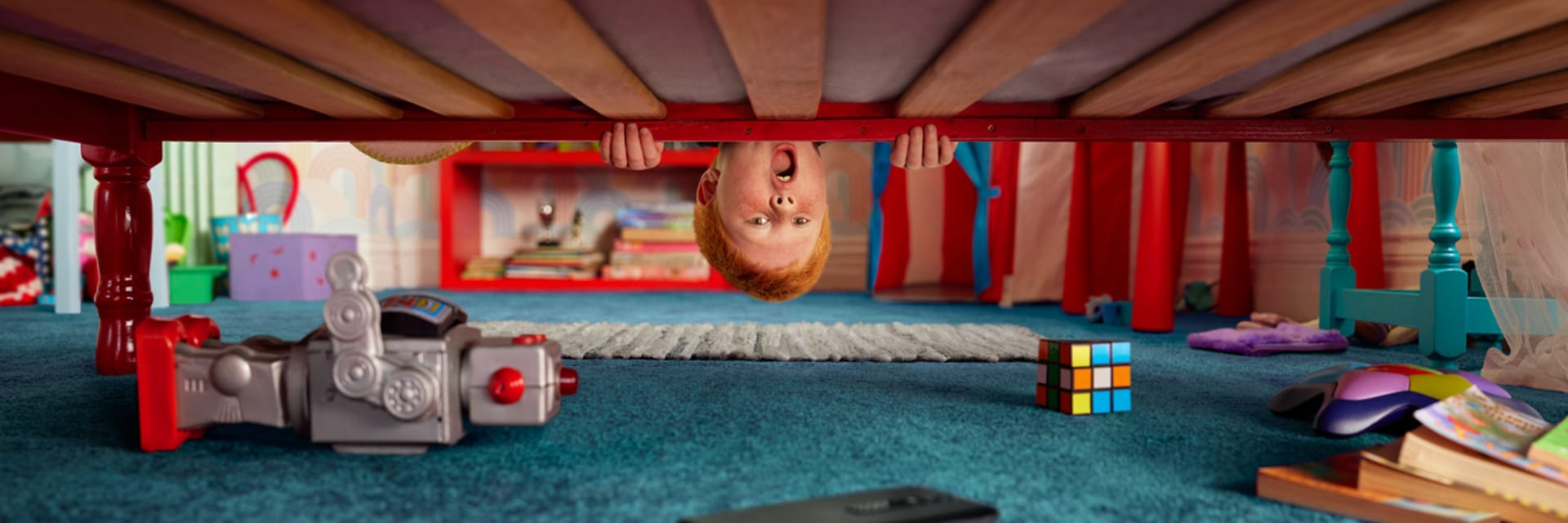 Vodafone - Home of Trade In. A young boy looks underneath his bed to find an old smart phone surrounded by old toys and books