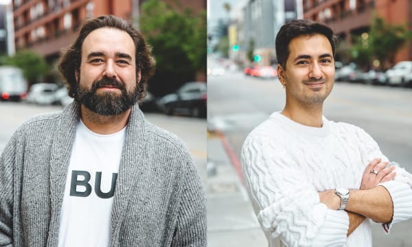 Left: a white male with shoulder-length brown hair and a beard smiles at the camera wearing a grey cardigan over a white T-shirt. Right: a tan-skinned male with short black hair smiles at the camera with arms folded in a white cable-knit sweater.