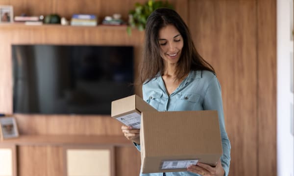 Woman accepting a brown package while smiling