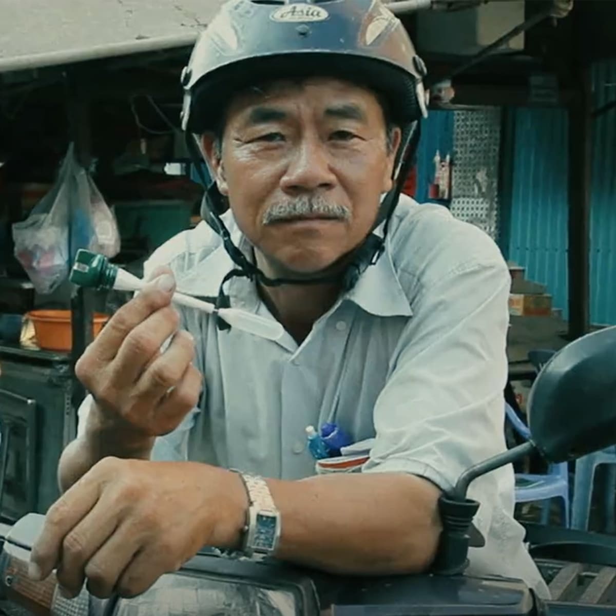 Motor Cyclist holding an oil cap