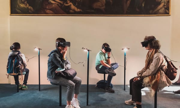 four people in a museum seated and following a 3D demo