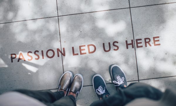 two people looking at a floor paining that reads: Passion led us here