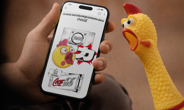 A rubber chicken screaming next to a person holding their phone